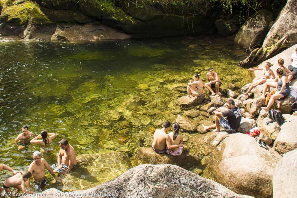 Imagem de vários turistas nas pedras da Cachoeira da Maromba.
